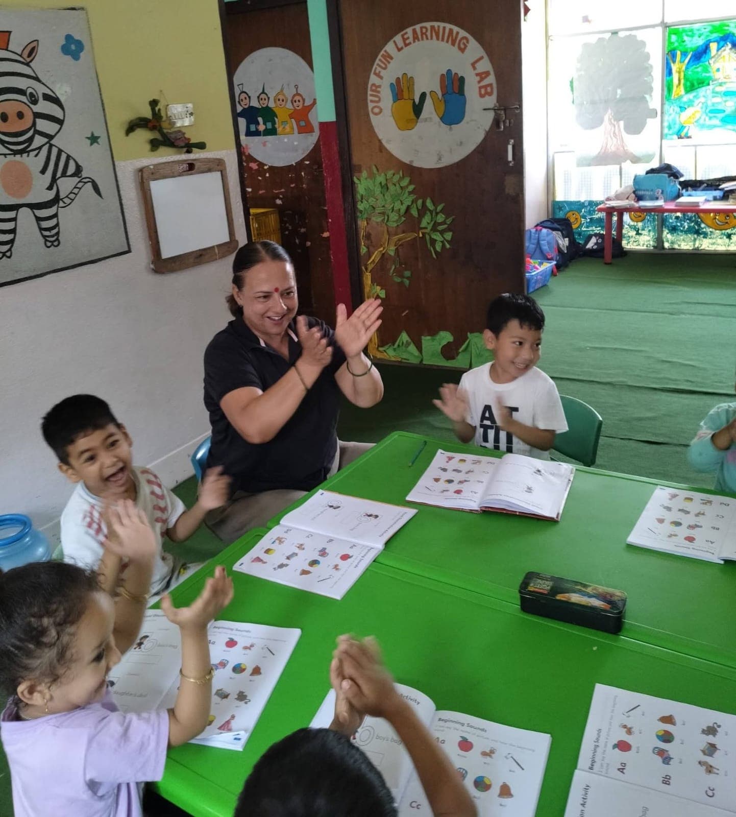 Children clapping along with their teacher during a phonics lesson