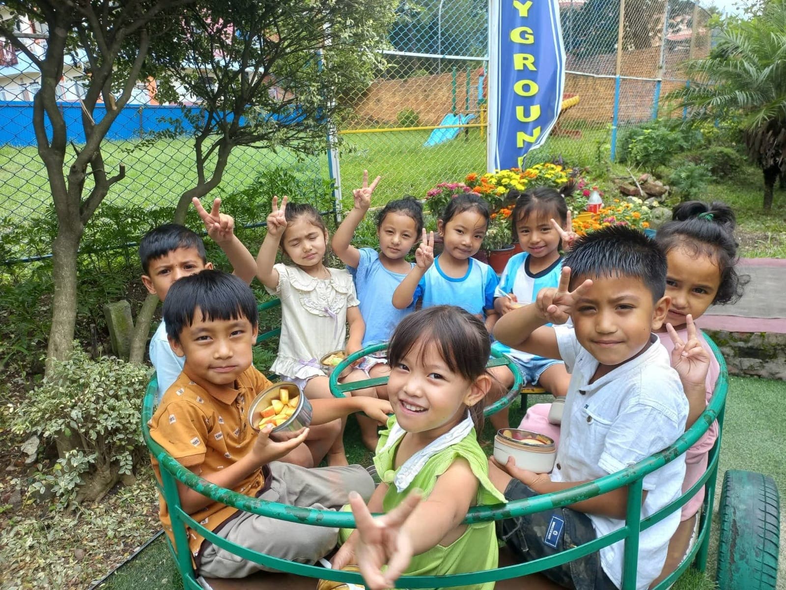 A cheerful group sharing fruit on the playground roundabout